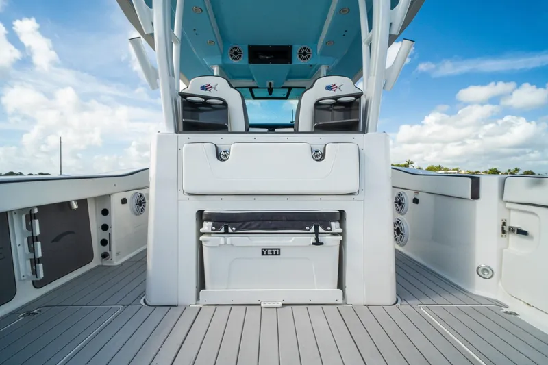 Slide: The Image of 2024 Crevalle 33 CSF boat interior with seating and storage, under a clear blue sky. - 33