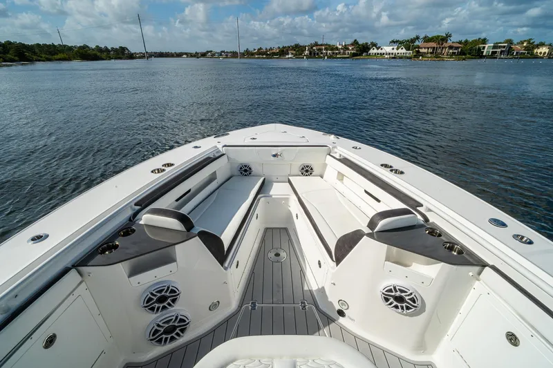 Slide: The Image of 2024 Crevalle 33 CSF boat interior with seating and speakers on a calm waterway. - 45