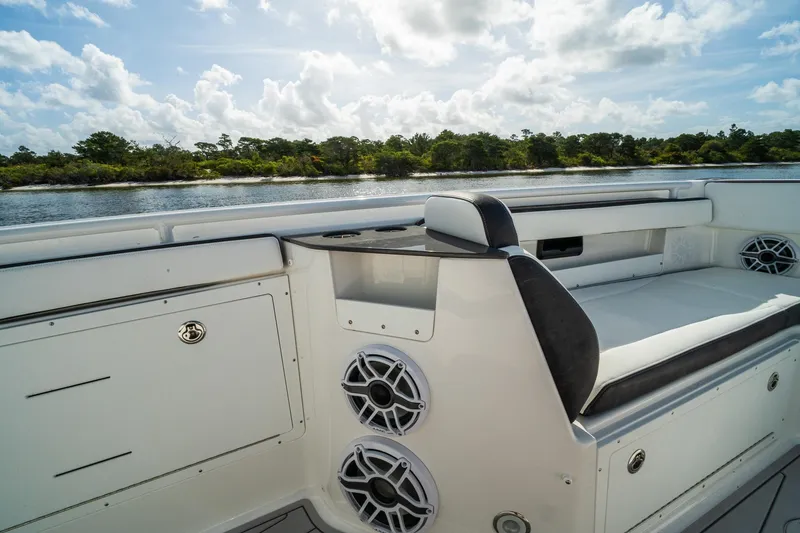 Slide: The Image of 2024 Crevalle 33 CSF boat interior with seating and speakers, overlooking a serene waterway. - 46