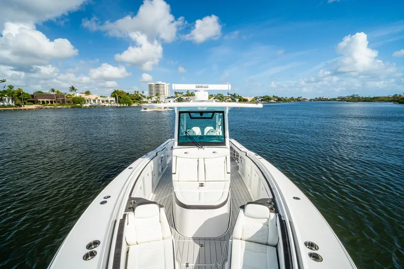 Slide: The Image of 2024 Crevalle 33 CSF boat on a serene waterway under a clear blue sky. - 57