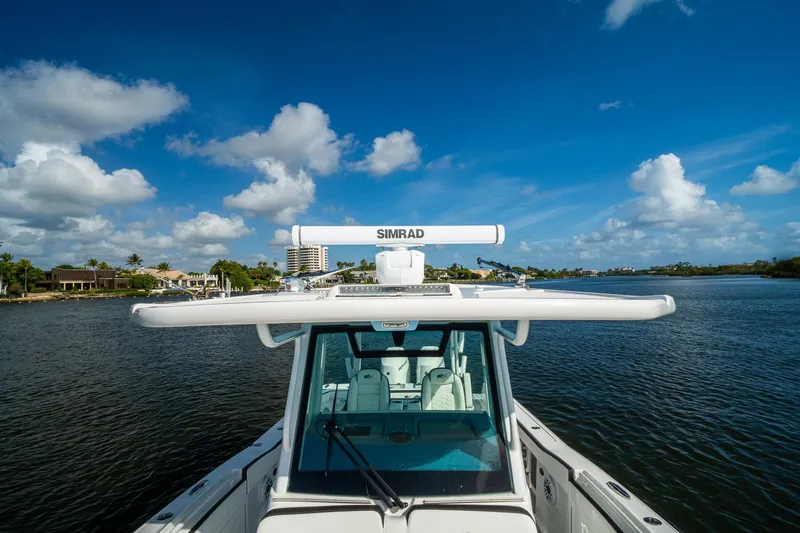 Slide: The Image of 2024 Crevalle 33 CSF boat on water, featuring Simrad radar, under a clear blue sky. - 58