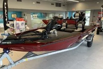 Slide: The Image of 2026 Crestliner XF 179 boat in showroom, red exterior, on trailer. - 4