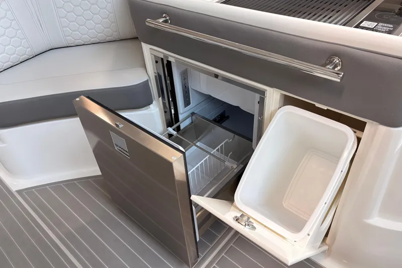 Slide: The Image of 2026 Sea Ray Sundancer 320 interior with open fridge and storage compartment. - 15