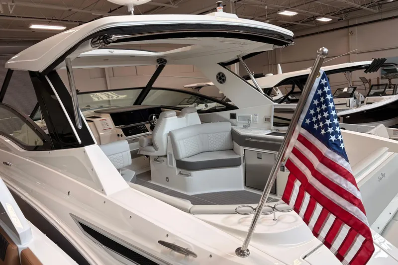 Slide: The Image of 2026 Sea Ray Sundancer 320 yacht interior with American flag, showcasing luxury seating and helm. - 3
