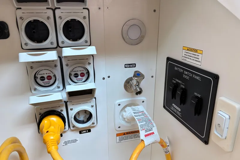Slide: The Image of Control panel of a 2026 Sea Ray Sundancer 320 boat with electrical and water connections. - 6