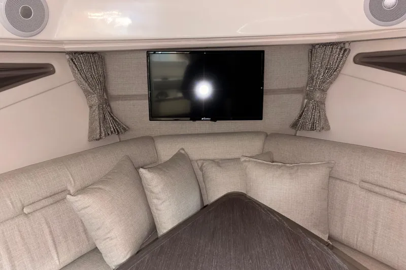 Slide: The Image of Interior of 2026 Sea Ray Sundancer 320 with cozy seating and mounted TV. - 8