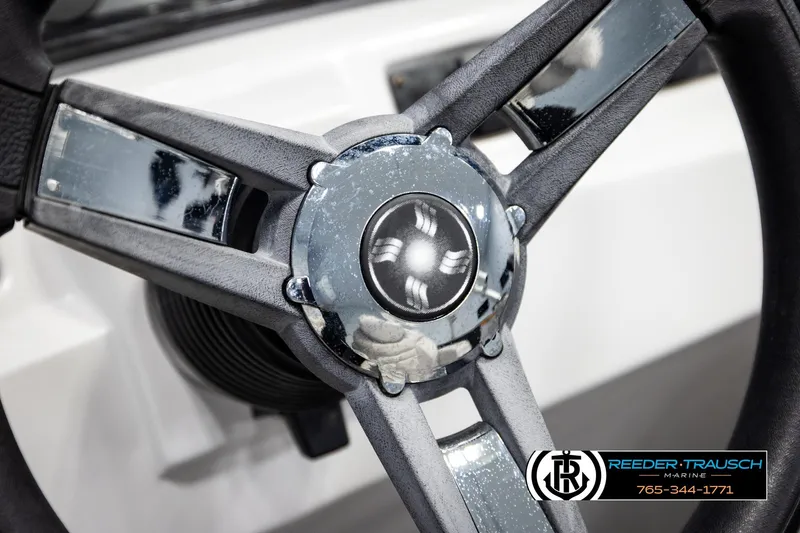 Slide: The Image of Steering wheel of 2019 Sweetwater SW2086c boat, featuring chrome accents and logo. - 26