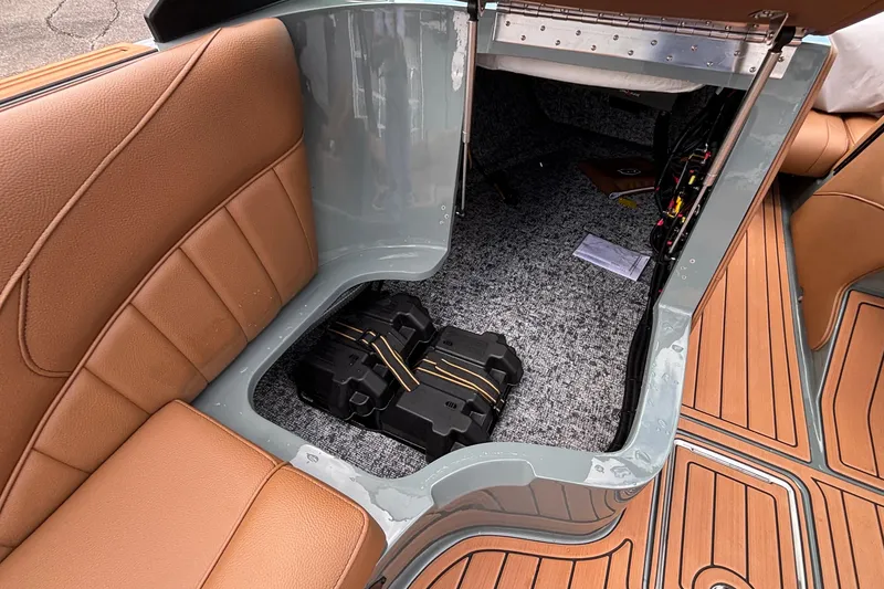 Slide: The Image of 2026 MB B52 23 Classic boat interior storage with brown seating and visible battery compartment. - 23