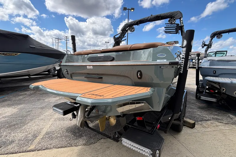 Slide: The Image of 2026 MB B52 23 Classic boat with teak swim platform, parked outdoors under blue sky. - 46