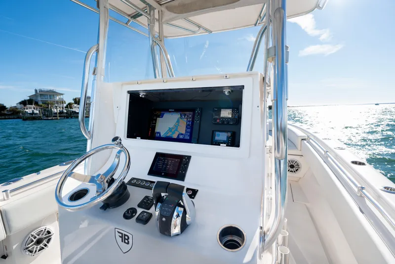 Slide: The Image of 2023 Contender 28 Sport boat dashboard with navigation system on open water. - 13