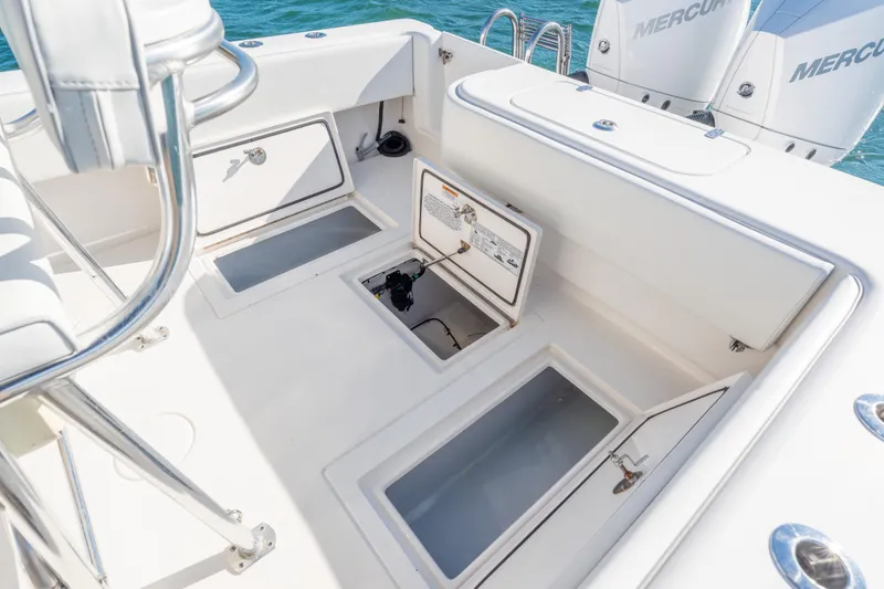 Slide: The Image of 2023 Contender 28 Sport boat interior with open storage compartments and Mercury engines. - 14