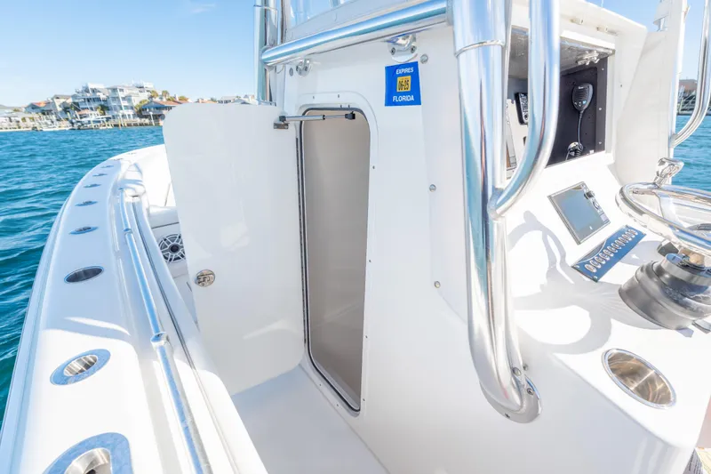 Slide: The Image of 2023 Contender 28 Sport boat interior with open cabin door, sleek design, and ocean view. - 15