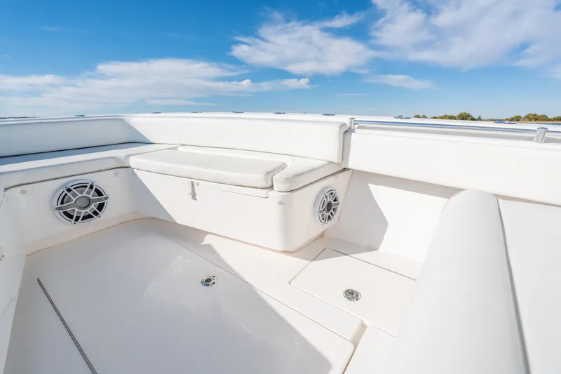 Slide: The Image of 2023 Contender 28 Sport boat interior with white seating and speakers under blue sky. - 7