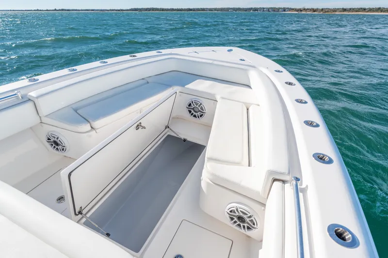 Slide: The Image of 2023 Contender 28 Sport boat interior with open storage, white seating, and ocean view. - 9