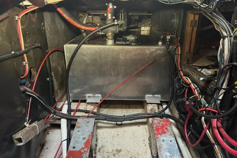 Slide: The Image of Engine compartment of a 1980 Nordic 44 boat, featuring wiring and a metal tank. - 14