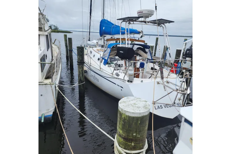 Slide: The Image of 1980 Nordic 44 sailboat docked, featuring blue sail cover and marina setting. - 3