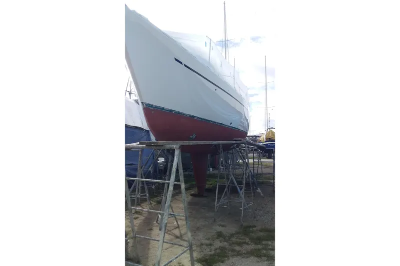 Slide: The Image of 1980 Nordic 44 sailboat on stands, undergoing maintenance in a boatyard. - 5