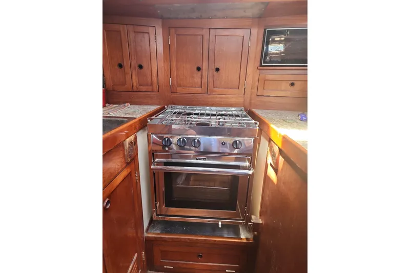 Slide: The Image of Wooden boat kitchen with Nordic 44 stove, 1980 model, featuring cabinets and countertop. - 8