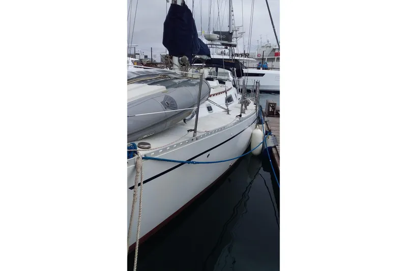 Slide: The Image of 1980 Nordic 44 sailboat docked at marina, featuring sleek design and white hull. - 9
