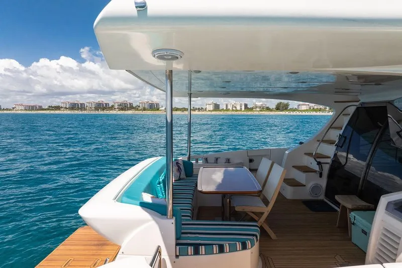 Slide: The Image of Luxurious 2011 Azimut 70 yacht with elegant deck seating, overlooking serene ocean and coastal skyline. - 112