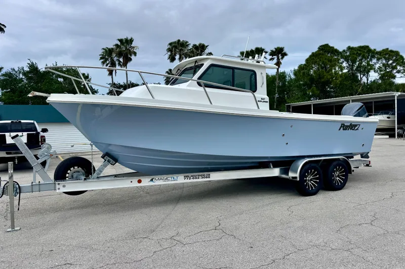 The Image of 2026 Parker 247 Explorer boat on trailer, parked outdoors with palm trees in background. - 1