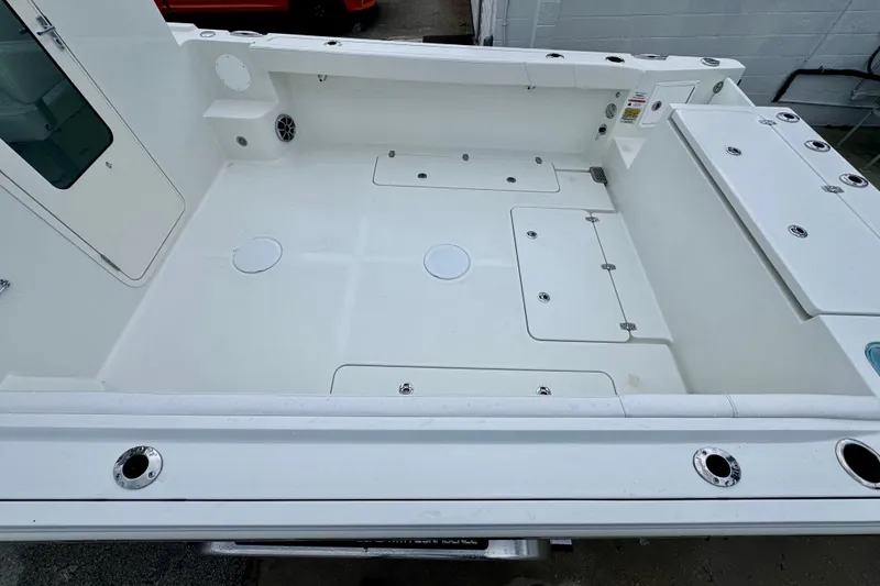 Slide: The Image of Spacious deck of 2026 Parker 247 Explorer boat, featuring storage compartments and rod holders. - 11