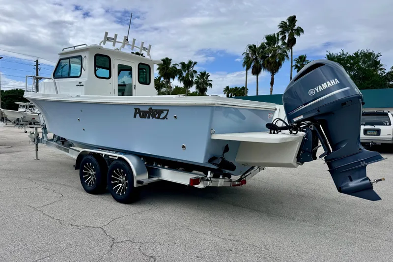 Slide: The Image of 2026 Parker 247 Explorer boat with Yamaha engine on trailer, parked outdoors. - 3