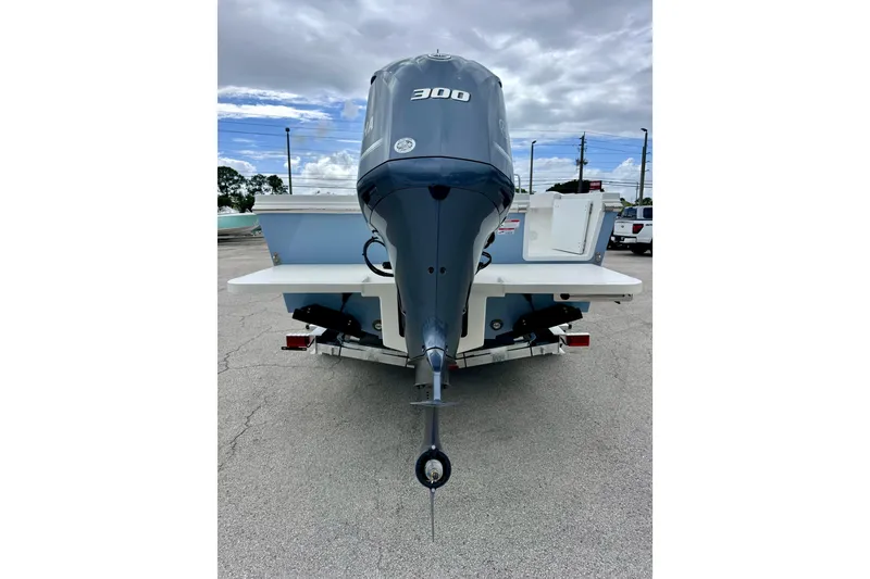 Slide: The Image of 2026 Parker 247 Explorer boat with powerful outboard motor, parked on concrete under cloudy sky. - 4