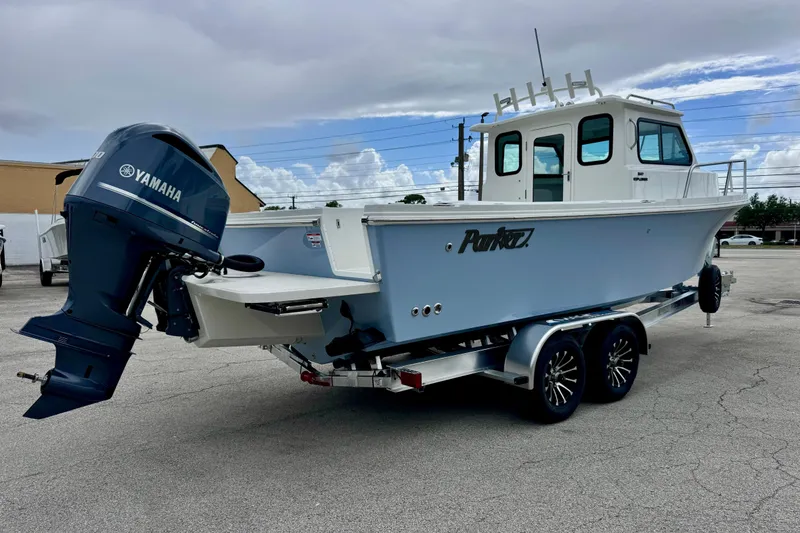 Slide: The Image of 2026 Parker 247 Explorer boat with Yamaha engine on a trailer, parked outdoors. - 5