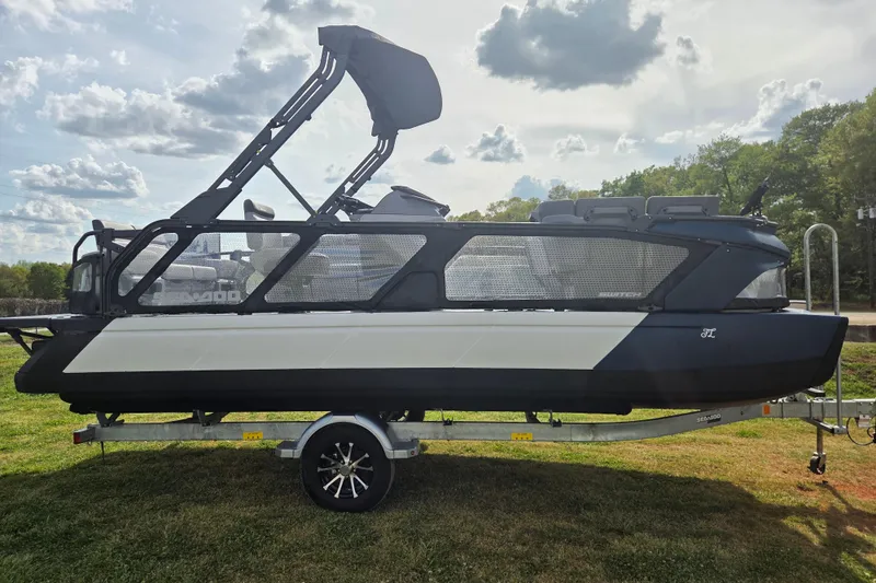 Slide: The Image of 2024 Sea-Doo Switch Cruise 21 pontoon boat on trailer, side view, outdoors. - 3