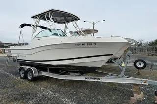 The Image of 2019 Striper 230 DC boat on trailer, parked outdoors. - 0