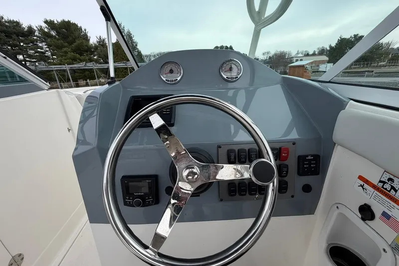 Slide: The Image of Steering console of a 2019 Striper 230 DC boat with gauges and controls. - 19
