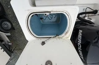 Slide: The Image of Open hatch on 2019 Striper 230 DC boat with visible storage compartment. - 29
