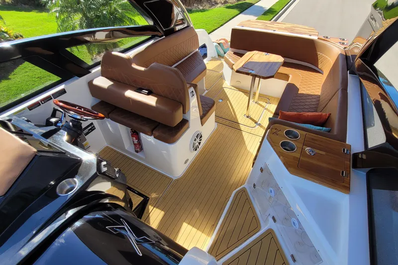 Slide: The Image of 2023 NX Boats NX340 interior with luxurious seating and wooden accents. - 10