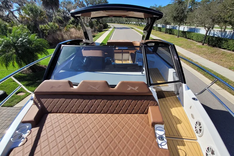 Slide: The Image of 2023 NX Boats NX340 luxury boat with brown leather seating and sleek design. - 13