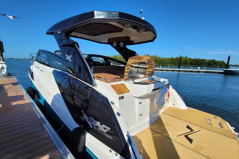 Slide: The Image of 2023 NX Boats NX340 yacht docked, showcasing sleek design and luxurious features. - 2
