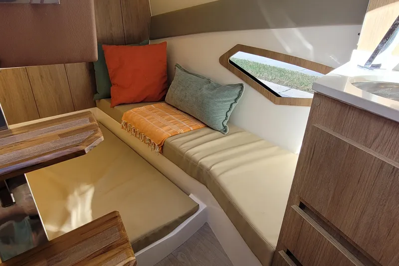 Slide: The Image of Interior of 2023 NX Boats NX340, featuring cozy seating with colorful cushions and wooden accents. - 20
