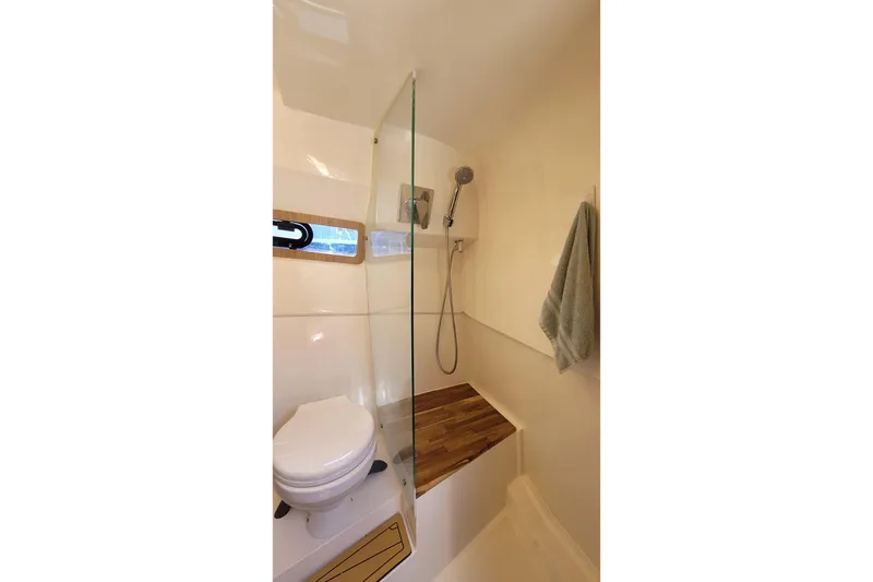Slide: The Image of Modern bathroom in 2023 NX Boats NX340, featuring shower and toilet with wooden accents. - 26