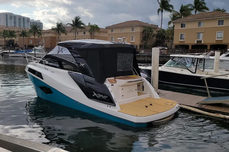 Slide: The Image of 2023 NX Boats NX340 docked in a marina, featuring sleek design and modern amenities. - 7