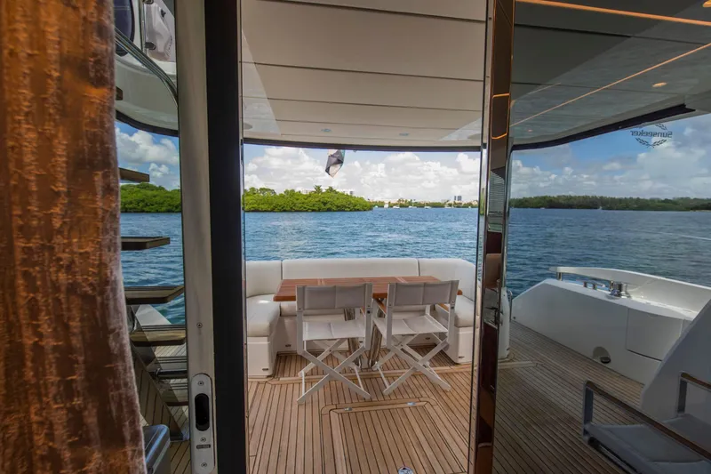 Slide: The Image of Luxurious Sunseeker Manhattan 68 yacht deck with seating, overlooking serene water and lush greenery. - 104