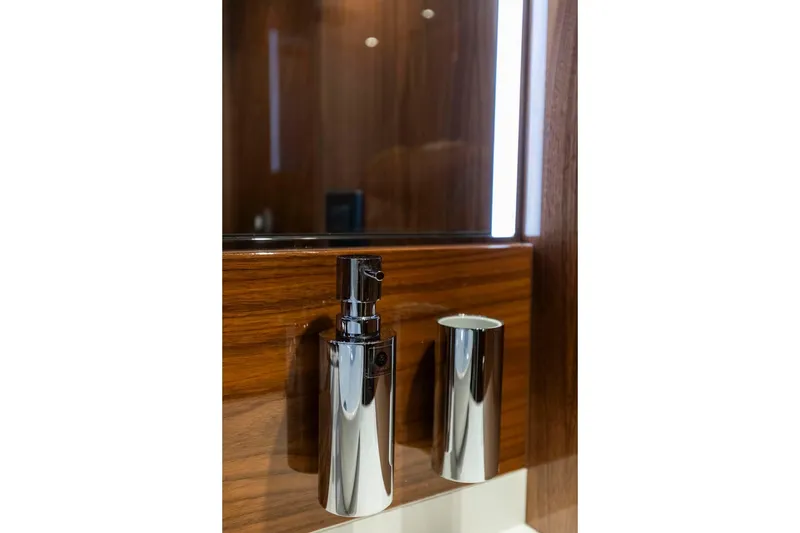 Slide: The Image of Chrome soap dispenser on Sunseeker Manhattan 68 yacht, 2021 model, with wooden panel background. - 13
