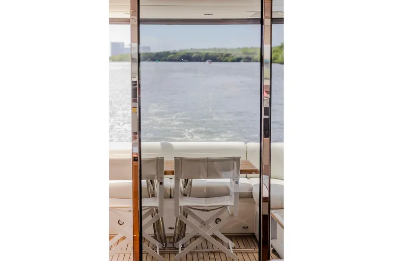 Slide: The Image of Sunseeker Manhattan 68 yacht interior with elegant seating, overlooking serene water view. - 130