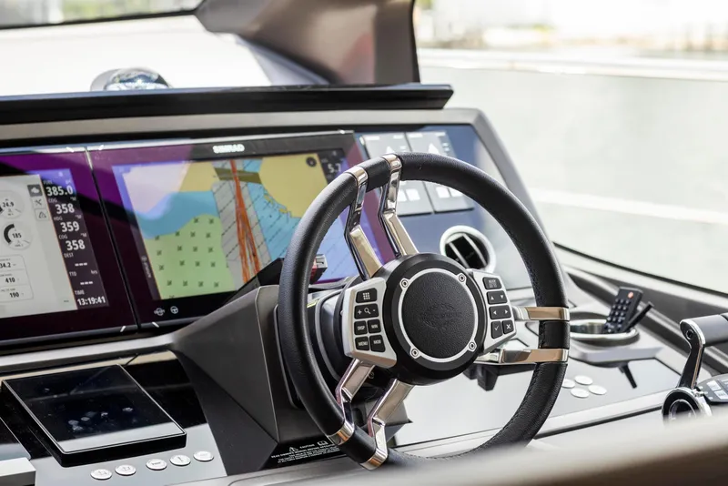 Slide: The Image of Steering wheel and dashboard of 2021 Sunseeker Manhattan 68 yacht, featuring advanced navigation displays. - 131