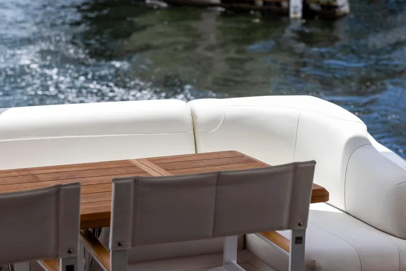 Slide: The Image of Luxurious seating area on 2021 Sunseeker Manhattan 68 yacht with wooden table by the water. - 136