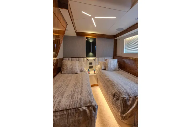 Slide: The Image of Luxurious twin cabin interior of 2021 Sunseeker Manhattan 68 yacht, featuring elegant bedding and modern lighting. - 27