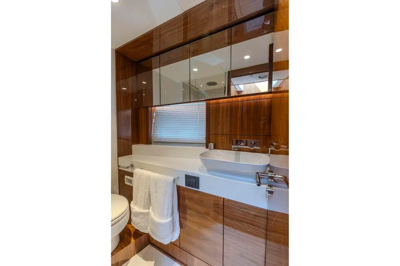 Slide: The Image of Luxurious bathroom in 2021 Sunseeker Manhattan 68 yacht, featuring sleek wood cabinetry and modern fixtures. - 30