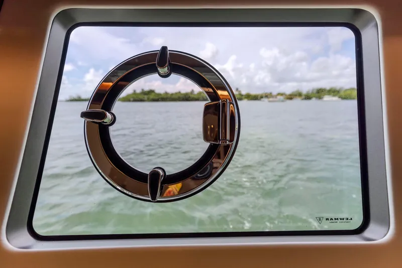 Slide: The Image of Porthole view from 2021 Sunseeker Manhattan 68 yacht, overlooking serene waters and cloudy sky. - 31