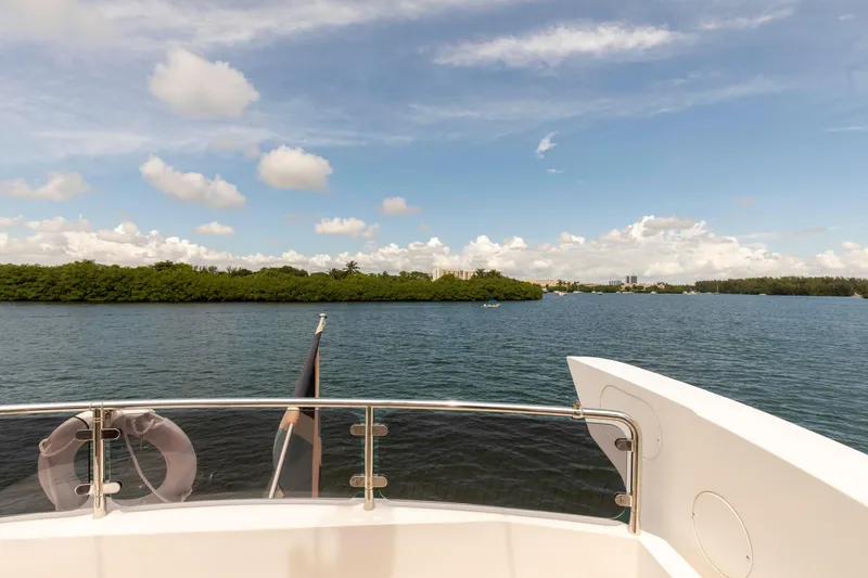 Slide: The Image of View from Sunseeker Manhattan 68 yacht, overlooking serene water and lush greenery, 2021 model. - 56