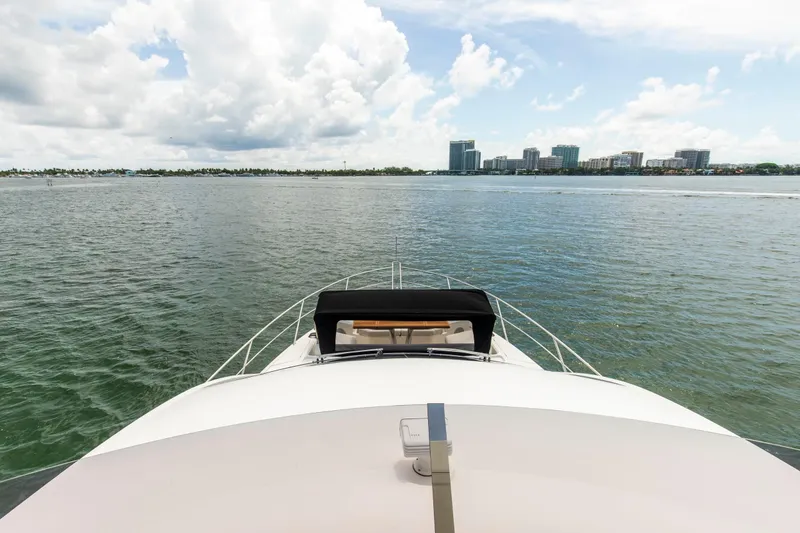 Slide: The Image of Bow view of 2021 Sunseeker Manhattan 68 yacht on calm waters with city skyline. - 68