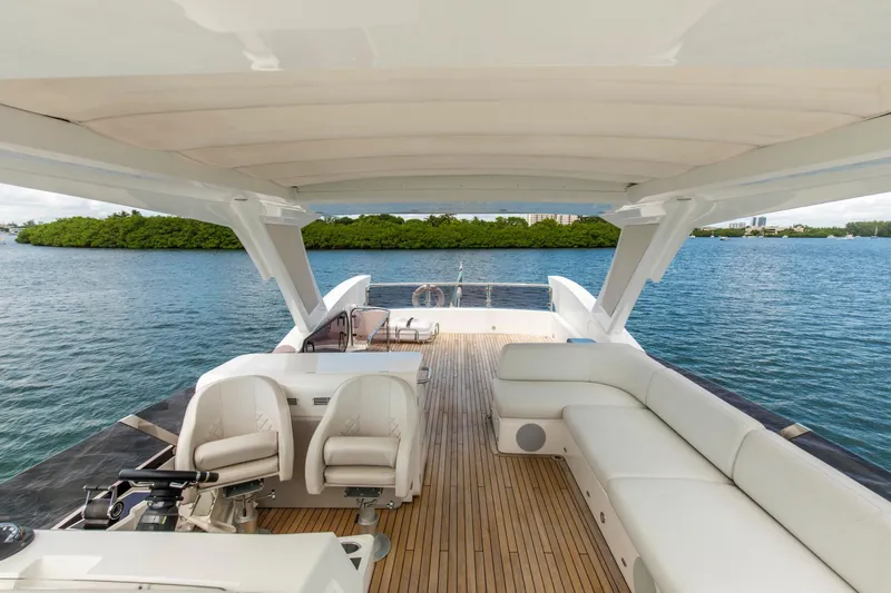 Slide: The Image of Luxurious Sunseeker Manhattan 68 yacht deck with seating, overlooking serene waters, 2021 model. - 69
